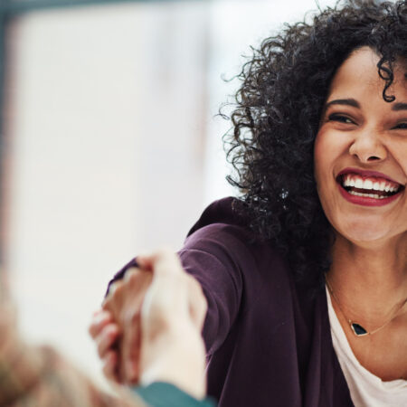 Handshake with a happy, confident and excited business woman or human resources manager and a female colleague, partner or employee. An agreement, deal or meeting with a coworker in the boardroom.